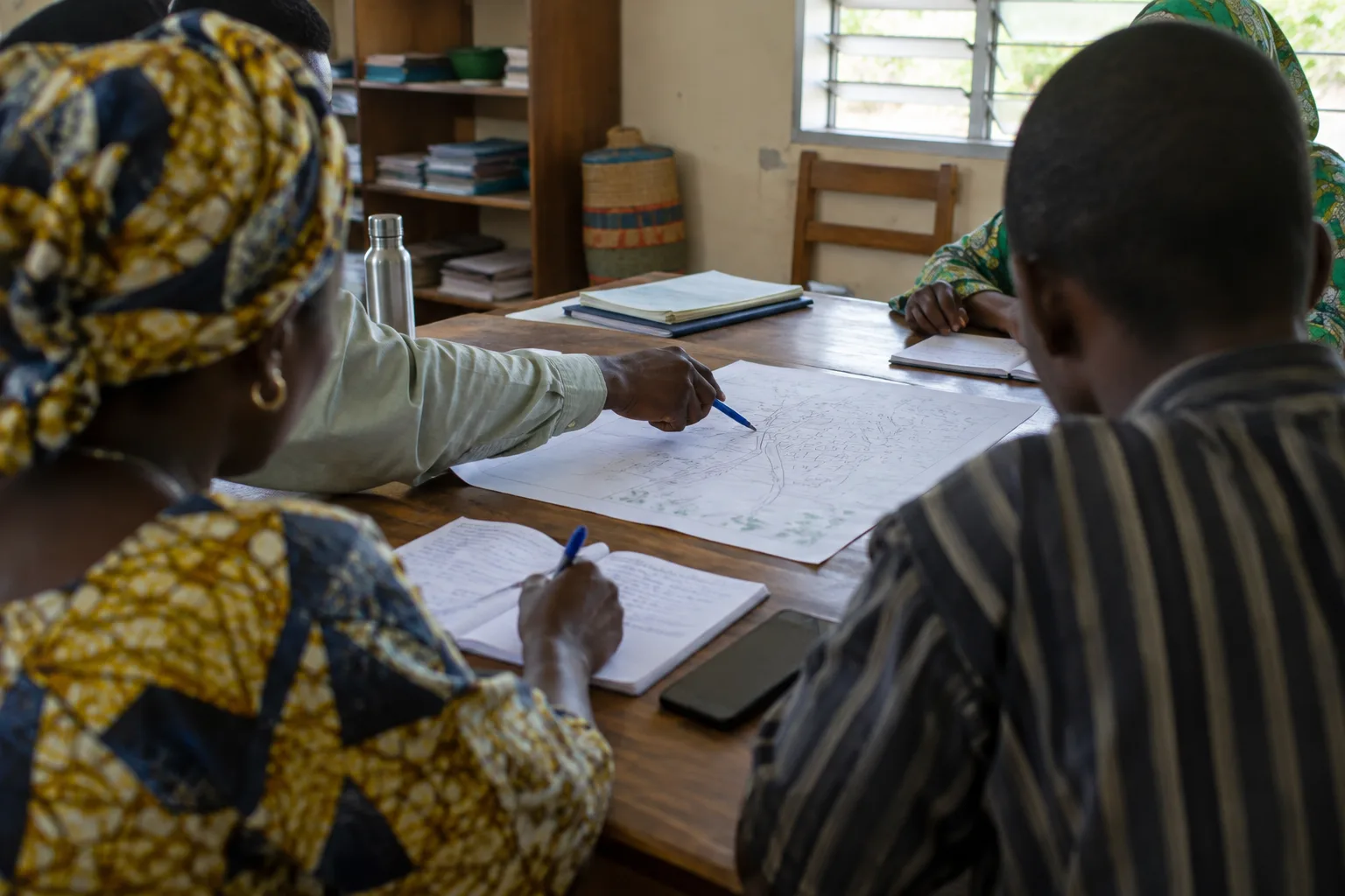 Une équipe associative examine des notes de projet autour d’une table.